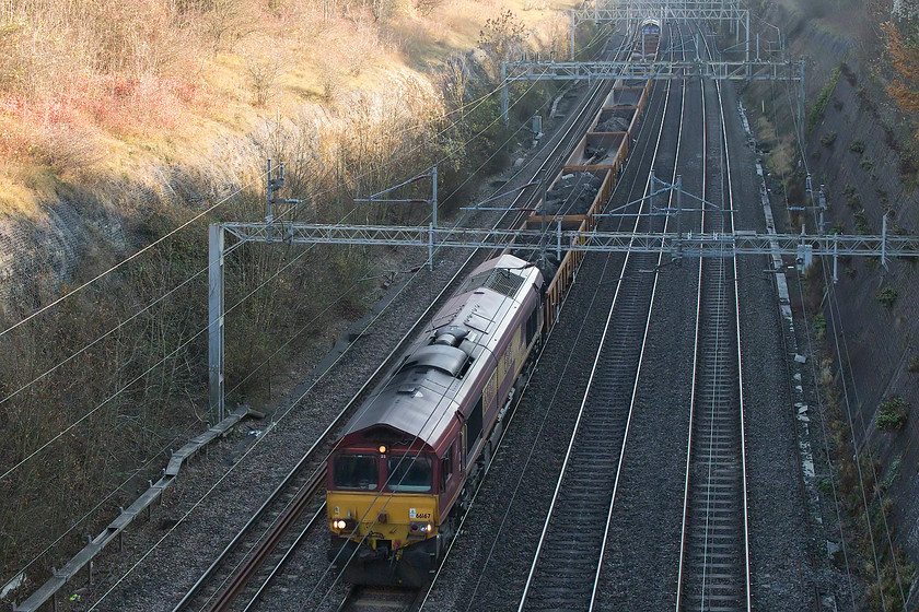 66167 & 66170, 12.20 London Euston-Bescot Downside, Roade Cutting 
 By this time of day (early afternoon) on a late autumn afternoon, Roade Cutting is plunged into shadow. However, with modern camera equipment, this does not preclude the taking of half decent pictures. Here, 66167 leads with 66170 dead in tow on the rear with another engineer's train, the 12.20 Euston to Bescot Downside. This train is composed of half full MHA ballast/spoil 2-axle wagons. 
 Keywords: 66167 66170 12.20 London Euston-Bescot Downside Roade Cutting