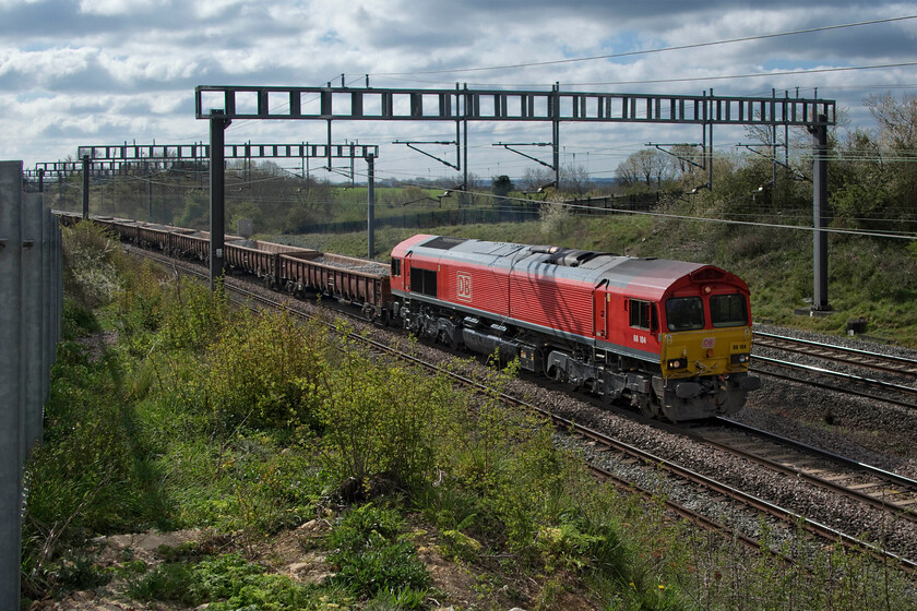 66104, 09.48 Hanslope Junction-Bescot Up Engineering sidings (6G55, 148E), between Roade & Ashton 
 I have very few photographs of 66104 and this is my first with it wearing its smart and recently applied DB red livery. Whilst the bodywork looks smart the mechanics did not appear to be in such good fettle with a heavy exhaust cloud following the locomotive as it led the 6G55 09.48 Hanslope Junction (two miles south from this location) to Bescot Yard. The train was composed of a shortish rake of MDA low sided box wagons conveying used ballast from the fast lines somewhere between Hanslope and Wolverton back to Bescot for cleaning and recycling. Out of sight at the rear of the train were a number of track machines. 
 Keywords: 66104 09.48 Hanslope Junction-Bescot Up Engineering sidings 6G55 between Roade & Ashton DB