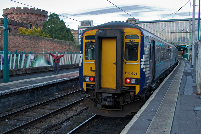 Andy & 156462, SR 23.10 Carlisle-Dumfries (2L74, 4E), Carlisle station 
 Andy looks to be very excited at the prospect of a day's traversing the Cumbrian Coast line the following day! I doubt that it is 156462 working the 2L74 23.10 service to Dumfries that is causing him to throw his hands in the air! Notice the Grade 1 listed western tower of Calisle's impressive citadel that was originally commissioned by Henry VIII even though the towers were both rebuilt by Thomas Telford and Sir Robert Smirke in 1822. 
 Keywords: Andy 156462 23.10 Carlisle-Dumfries 2L74 Carlisle station ScotRail