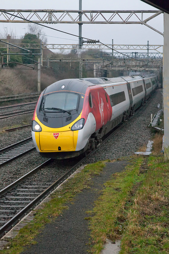 390123, VT 07.20 London Euston-Manchester Piccadilly (1H09, 1E), site of Castlethorpe station 
 Looking very smart and brightening up the dismal weather, 390123 races past the site of Castlethorpe station working the 07.20 Euston to Manchester Piccadilly. When compared to London Northwestern's awful new livery that is slowly ruining their class 350s this new style Virgin look is by way of a complete contrast! 
 Keywords: 390123 VT 07.20 London Euston-Manchester Piccadilly 1H09 1E site of Castlethorpe station