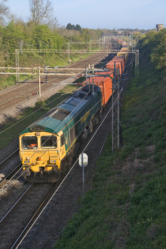 66523, 03.39 Garston-London Gateway (4L52, 3E), Victoria bridge 
 The nose of 66523 just catches the morning sunshine as it passes Victoria bridge with the village of Roade seen in the background. It is leading the weekday daily 03.39 Garston to London Gateway 4L52 Freightliner. With no freight due for twenty minutes, I had to head off for work in Milton Keynes but a very reasonable start to the day was had! 
 Keywords: 66523 03.39 Garston-London Gateway 4L52 Victoria bridge Freightliner