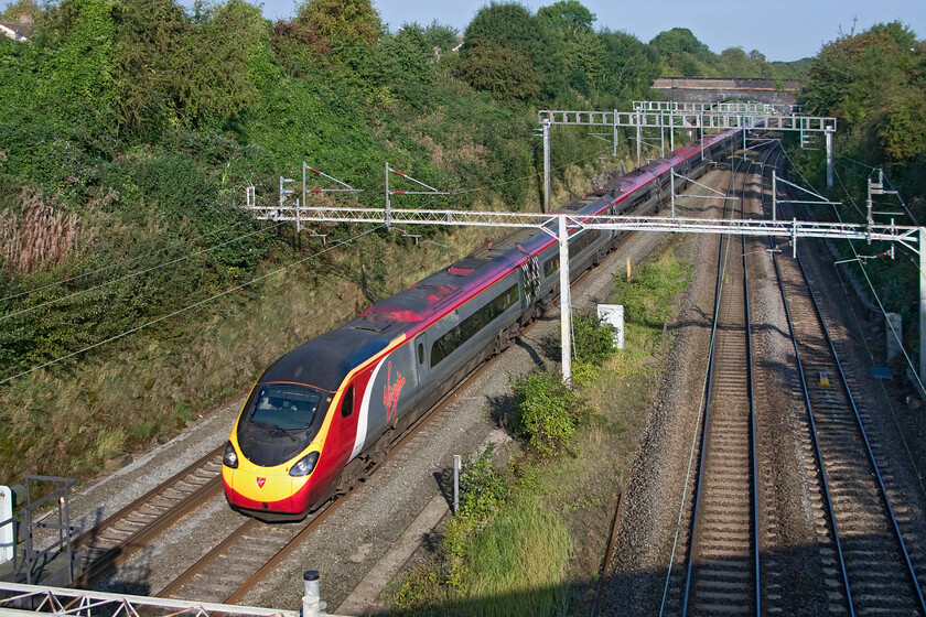 390124, VT 08.05 Wolverhampton-London Euston (1B01), A508 Bridge 
 390124 sweeps through Roade taken from the A508 road bridge. The Virgin Pendolino is working the 08.05 Wolverhampton to Euston 1B01 service. This is one of the first up 'fast' services on a Sunday morning. 
 Keywords: 390124 08.05 Wolverhampton-London Euston 1B01 A508 Bridge