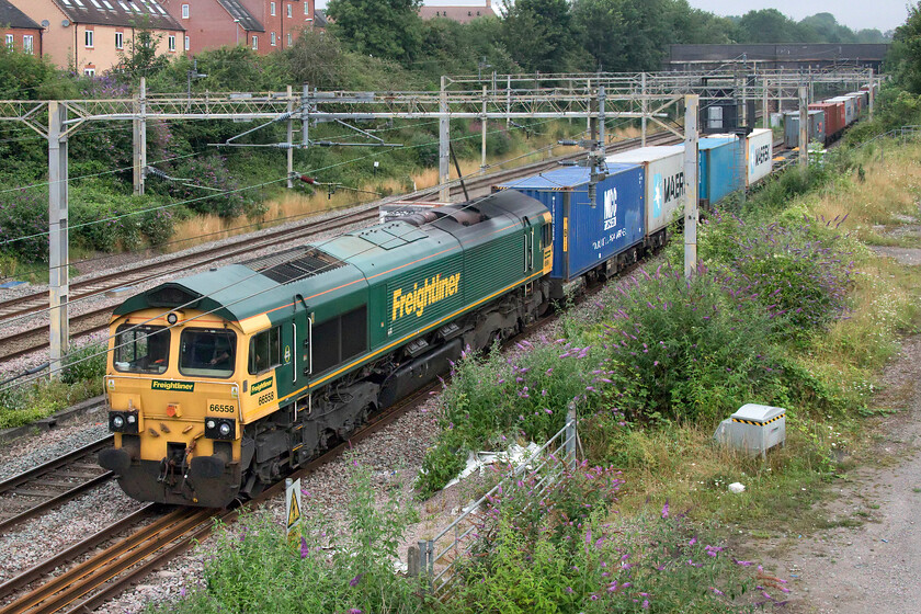 66558, 04.10 Crewe Basford Hall-Felixstowe North (4L89), site of Roade station 
 On an incredibly dull August morning, something that characterised the whole month during the summer of 2021, 66558 passes the site of Roade station. The Freightliner Class 66 is leading the 04.10 Crewe Basford Hall to Felixstowe 4L89 service that was well loaded on this particular morning. 
 Keywords: 66558 04.10 Crewe Basford Hall-Felixstowe North 4L89 site of Roade station Freightliner