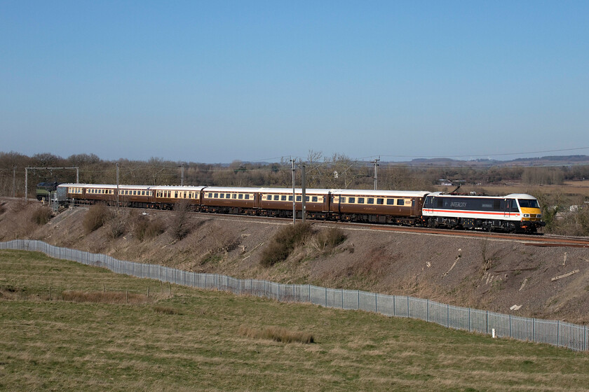 90002 & 47810, 09.50 Liverpool Lime Street-Wembley Central footex (1Z82, RT), Blisworth 
 Making a fine sight as it passes through the Northamptonshire countryside near the village of Blisworth 90002 'Wolf of Badenoch' leads a set of Pullman style MkII stock with 47810 'Crewe Diesel Depot' hanging on at the rear. The train was supposed to have been hauled by another of LSL's fleet, 47501 'Craftsman' but it was failed with 90002 substituted. Personally, I think that the AC electric is more interesting than the Class 47 especially when painted in this striking livery. The train was the first of two conveying Liverpool fans from Merseyside to Wembley for the Carabao Cup also known as the League Cup. They would return later in the day after enjoying a thrilling match with Chelsea that saw Liverpool eventually 11-10 on penalties. 
 Keywords: 90002 47810 09.50 Liverpool Lime Street-Wembley Central footex 1Z82 Blisworth InterCity Swallow Wolf of Badenoch Crewe Diesel Depot