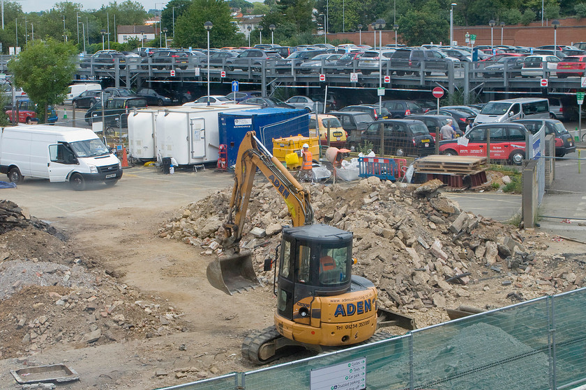 Demolition of old Northampton station 
 When the taxi rank and turning circle are complete I bet that the cabbies seen crammed together in the background will be relived. The excavator is busy in the foreground removing the old concrete footings with the area to become part of the car park. 
 Keywords: Demolition of old Northampton station