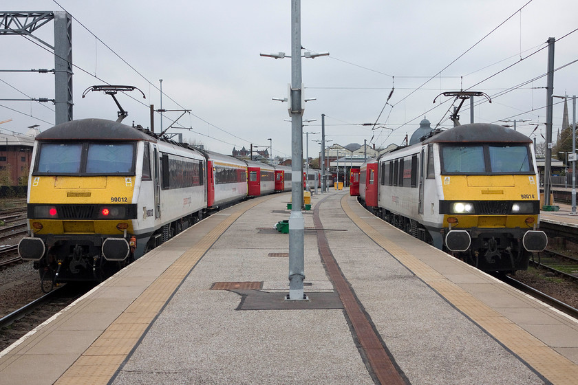 90012, 14.00 London Liverpool Street-Norwich (1P34, 3L) & 90014, 16.00 Norwich-London Liverpool Street (1P51, 10E), Norwich station 
 90012 'Royal Anglian Regiment' has arrived at Norwich and terminated with the 14.00 from Liverpool Street. Next to it, 90014 'Norfolk & Norwich Festival' is ready to leave with the 16.00 1P51 service to Liverpool Street. The 90s have been the mainstay of these services for some years now but things are set to change with the introduction of units on the line to replace the loco. hauled services....progress, I am not at all sure? 
 Keywords: 90012 14.00 London Liverpool Street-Norwich 1P34 90014 16.00 Norwich-London Liverpool Street 1P51 Norwich station