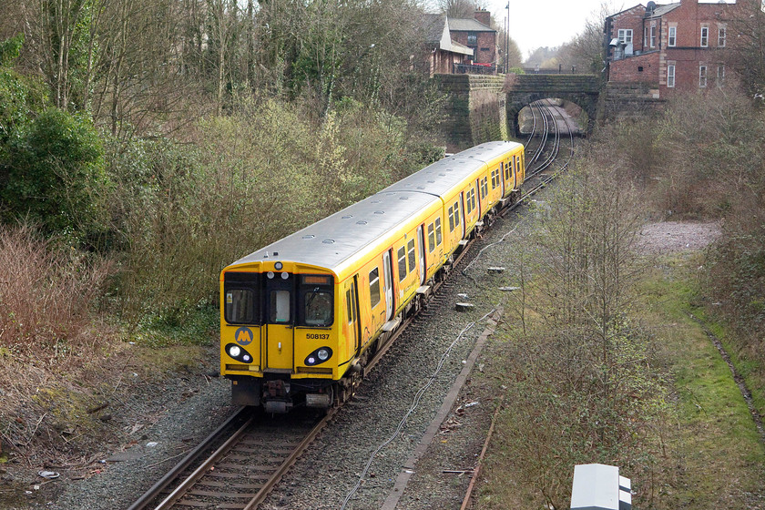 508137, MR 16.40 Liverpool Central-Ormskirk (2O42), Derby Street bridge, Ormskirk 
 One of Merseyrail's veteran class 508s arrives at Orsmkirk. 508137 is about to go under the Derby Street bridge with the 16.40 from Liverpool Central. The trackbed of the former down line that was removed when the line was 'chopped' in half can be seen to the right. 
 Keywords: 508137 16.40 Liverpool Central-Ormskirk 2O42 Derby Street bridge, Ormskirk