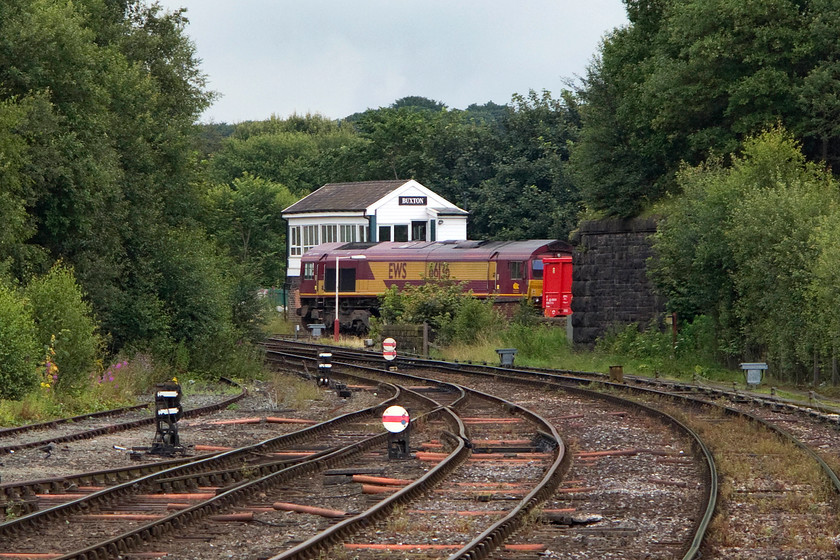 66136, 13.05 Dowlow-Ashburys (6H57), Buxton signal box 
 A rather distant shot of 66136 leading the 13.05 Dowlow quarry to Ashbuys stone train. I believe that this working has the 6H57 headcode but am happy for readers to advise me otherwise. The train is seen passing Buxton's nicely looked after LNWR 1894 signal box. 
 Keywords: 66136 13.05 Dowlow-Ashburys 6H57 Buxton signal box