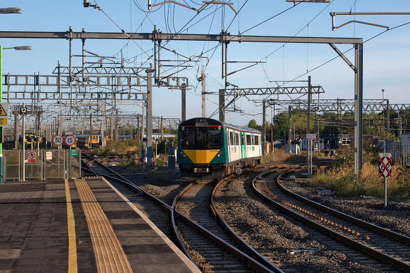 230005, LN 08.00 Bletchley-Bedford (2S07, 1L), Bletchley station 
 In lovely 'clean' September lighting the 08.00 Bletchley to Bedford service worked by 230005 leaves its starting point curving away from the station on to the Marston Vale line. Andy and I travelled on this route a few weeks ago and sampled the converted LU stock that now work the line. Off to the left of the unit are various other London NorthWestern units stabled in Bletchley's yard and off to the right is the failed 4L96 with 66587 'As One, We Can' on the front. Something had obviously gone wrong the previous evening as it passed Roade on time at 20.43 to be then looped and stopped just ten miles south here at Bletchley. The train remained in the loop until eventually moving off some five days later on 21.09.22...can anybody shed any light? 
 Keywords: 230005 08.00 Bletchley-Bedford 2S07 Bletchley station London Northwestern Marston Vale