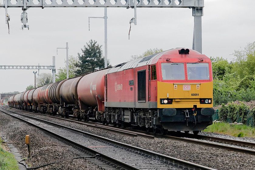 60091, 13.00 Theale-Roberstson (6B33), Steventon Causeway Crossing 
 A regular daily working on the GWML is the 13.00 (or thereabouts) Theale to Roberston empty oil tankers. It is usually hauled by a class 60 as it's such a heavy train on its up working when the tanks are full. Here it is seen passing Steventon's second level crossing, Causeway, with 60091 'Barry Needham' thrashing at the front! Not a great picture but the camera had a 'funny' and played up for a short while massively over-exposing for a few shots. It still does it occasionally now and is something that I have read about that is a bit of an issue for the Canon 5D Mk.II. 
 Keywords: 60091 13.00 Theale-Roberstson 6B33 Steventon Causeway Crossing