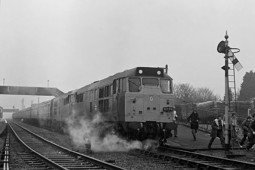 31256 & 31208, outward leg of The Crewe Campaigner Relief, 07.35 London Paddington-Crewe (1Z68), Moreton-in-Marsh station 
 With steam escaping from leaky glands on the pipework of 31256, The Crewe Campaigner Relief railtour is seen at Moreton-in-Marsh station. 31208 is tucked in behind the leading locomotive. The train has paused at the this fog bound Cotswold town for a photostop where large numbers of the enthusiast disgorged themselves to get their shots of the train. As I was one of the first out, I managed to get a reasonable shot with only a few others most of whom appear to have the same idea judging by they way that they look to be moving. 
 Keywords: 31256 31208 The Crewe Campaigner Relief 07.35 London Paddington-Crewe 1Z68 Moreton-in-Marsh station