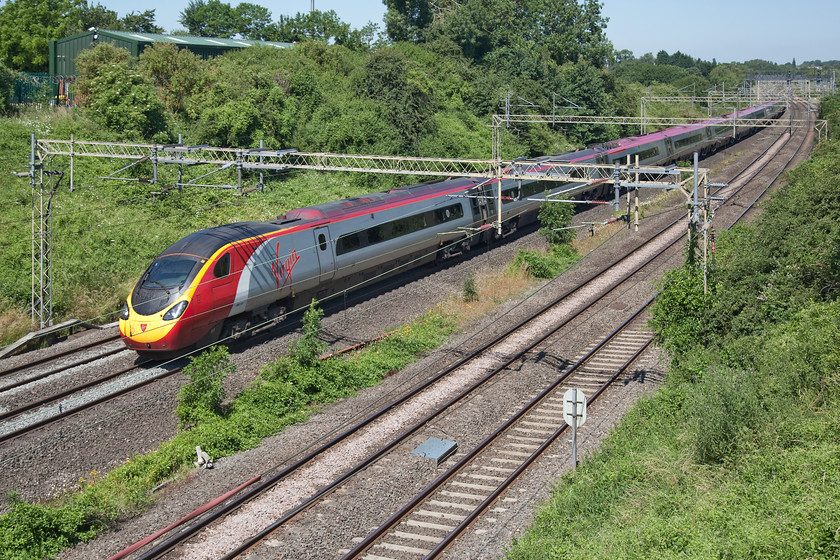 390157, VT 10.30 Birmingham New Street-London Euston (1B32, 1L), Victoria Bridge 
 This picture perfectly illustrates the problems associated with taking photographs during high summer. With sun high overhead during the day, there are deep shadows surrounding the subject that creates issues as seen here. 390157 'Chad Varah' races south past Victoria Bridge just south of Roade on the WCML with the 10.30 Birmingham New Street to London Euston. 
 Keywords: 390157 1B32 Victoria Bridge