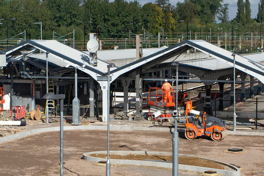 Redevelopment of old Northampton station 
 The previous two photographs show lots of plant and equipment associated with the rebuilding of the rear of Northampton's new station but no workers. Here is one on a cherry picker undertaking a task. The two archways shown in this view covered the interior of the old station the one to the left was the concourse and the one to the right was the ticket office and staff area. 
 Keywords: Redevelopment of old Northampton station