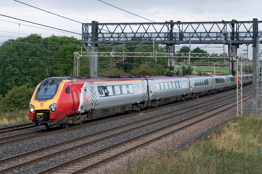 221104 & 221102, VT 04.48 Holyhead & 05.25 Blackpool North-London Euston (1R13 & 1K14), Roade hill 
 221104 'Sir John Franklin' leads 221102 'John Cabot' with the Virgin Trains 04.48 Holyhead/05.25 Blackpool to London Euston pass between Roade and Ashton. These two services come together at Crewe and if both are on-time can then join and continue their journey south as one train. If I had to travel from Holyhead to London early in the morning the thought of getting on a Class 221 Voyager at twenty minutes to five would fill me with dread! 
 Keywords: 221104 Sir John Franklin 221102 John Cabot 04.48 Holyhead 05.25 Blackpool North-London Euston 1R13 1K14 Roade hill Virgin Trains Voyager