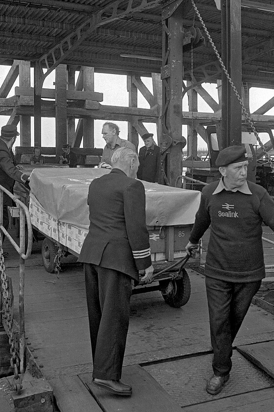 Loading MV Farringford, New Holland Pier 
 Trolleys are loaded on to the deck of the MV Farringford at New Holland prior to the 15.15 sailing to Hull Corporation Pier. Close examination of the boxes packed on to the first trolley appears to indicate that they were boxes of lettuce. Small-scale traffic such as this would hardly be cost-effective back in 1981 or now for that matter however, in terms of localism, it makes much sense if, for example, it was going to retailers in Hull and other parts of East Yorkshire. 
 Keywords: Loading MV Farringford New Holland Pier Sealink