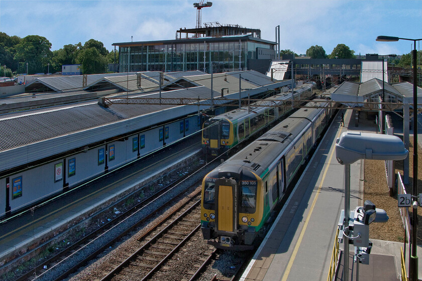 350244, LM 09.33 Birmingham New Street-London Euston (1W08) & 350105, LM 09.49 London Euston-Birmingham New Street (1W07), Northampton station 
 The temporary station footbridge installed at Northampton offers lofty views of the station. The new footbridge that has been built to link the new building to the platforms looks to be complete in this view. 350244 and 350105 wait at the station to work the 09.33 Birmingham New Street to London and the 09.49 Euston to New Street services respectively. 
 Keywords: 350244 09.33 Birmingham New Street-London Euston 1W08 350105 09.49 London Euston-Birmingham New Street 1W07 Northampton station London Midland Desiro