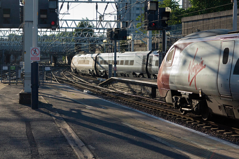 390148, VT 19.30 London Euston-Glasgow central (1S06, 2L) & 390119, VT 19.23 London Euston-Wolverhampton (9G41, 7L), London Euston station 
 A classic evening 'glint shot' at London Euston. To the right, 390148 'Virgin Harrier' waits to depart with the 1S06 19.30 to Glasgow Central. Behind it, 390119 'Virgin Warrior' departs working the 19.23 9G41 to Wolverhampton. 
 Keywords: 390148 1S06 390119 9G41 London Euston station