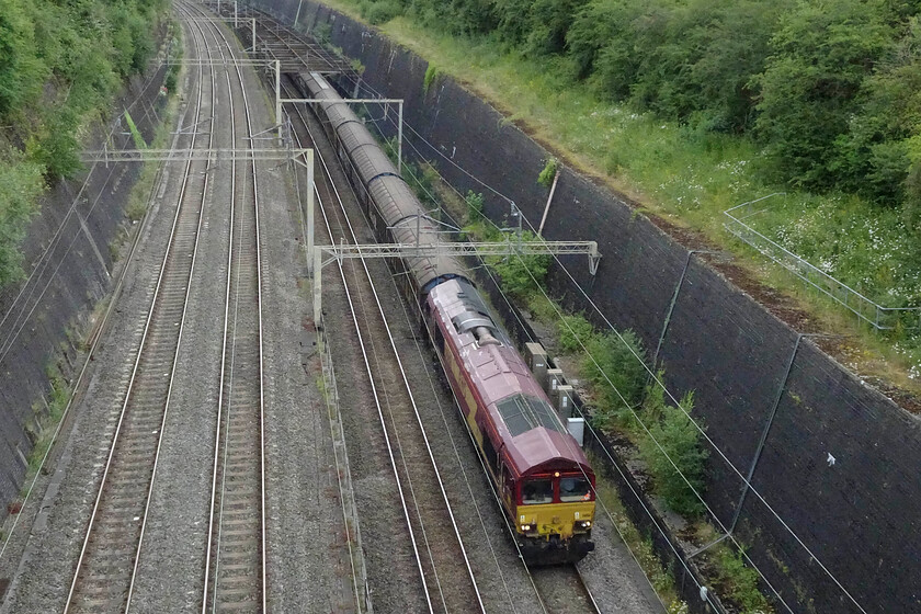 66164, 14.59 DIRFT-Dollands Moor (6O71, 3L), Roade cutting 
 Yesterday afternoon the 6O71 14.59 DIRFT (Daventry) to Dollanda Moor was worked by 66161, today it is similarly liveried 66164. The train is seen climbing through Roade cutting composed of its usual rake of Ferry-Wagons returning to the continent. 
 Keywords: 66164,14.59 DIRFT-Dollands Moor 6O71 Roade cutting EWS