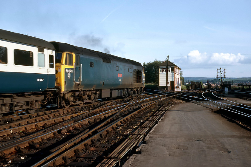 50041, 16.25 London Paddington-Plymouth (1B14), Exeter St. David's station 
 The fourth and final photograph of 50041 'Bulwark' as it leaves Exeter St. David's for the West Country. As the locomotive, that is leading the 16.25 Paddington to Plymouth, gets smokily away, it is about to pass the large and smart-looking Exeter West signal box and the incredible up inner home bracket signals just beyond the bridge crossing the River Exe. As well as supporting the inner homes controlled by the West signal box, it has the Middle box's distants and just below them some permissive arms for the movement of empty stock workings back into the station. The photograph is a fitting end to a superb day out! 
 Keywords: 50041 16.25 London Paddington-Plymouth 1B14 Exeter St. David's station Bulwark