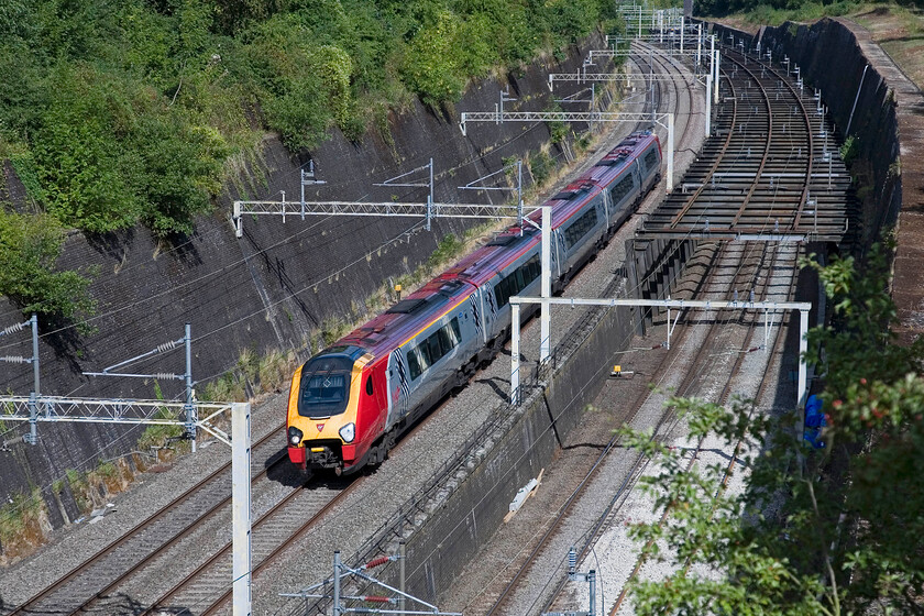 Class 221, VT 09.50 Birmingham New Street-London Euston, Roade cutting 
 The 09.50 Birmingham New Street to London Euston Virgin service has just entered Roade cutting worked by an unidentified Class 221 Voyager. The five-car unit is somewhat dwarfed by the vast and deep cutting that was and still is a magnificent Victorian civil engineering triumph! 
 Keywords: Class 221 VT 09.50 Birmingham New Street-London Euston Roade cutting Virgin Voyager