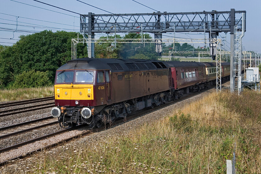 47826, outward leg of The Canterbury Tales Explore, Dumfries-Dover (1Z82), between Roade & Ashton 
 Unfortunately, the sun has just round too far to illuminate the flanks of 47826 as it roars through the Northamptonshire countryside just south of Roade. The rather dull-liveried West Coast Class 47 is leading the outward leg of The Canterbury Tales Explorer that left Dumfries at some unearthly hour. Passengers would have a pleasant afternoon exploring Kent before heading home. Unfortunately, they would arrive back even later than planned due to the failure of 47316 (on the rear in this photograph) leading the returning train at Bletchley with 47826 running round to lead for the rest of the journey. 
 Keywords: 47826 The Canterbury Tales Explore, Dumfries-Dover 1Z82 between Roade & Ashton WCR West Coast Railways