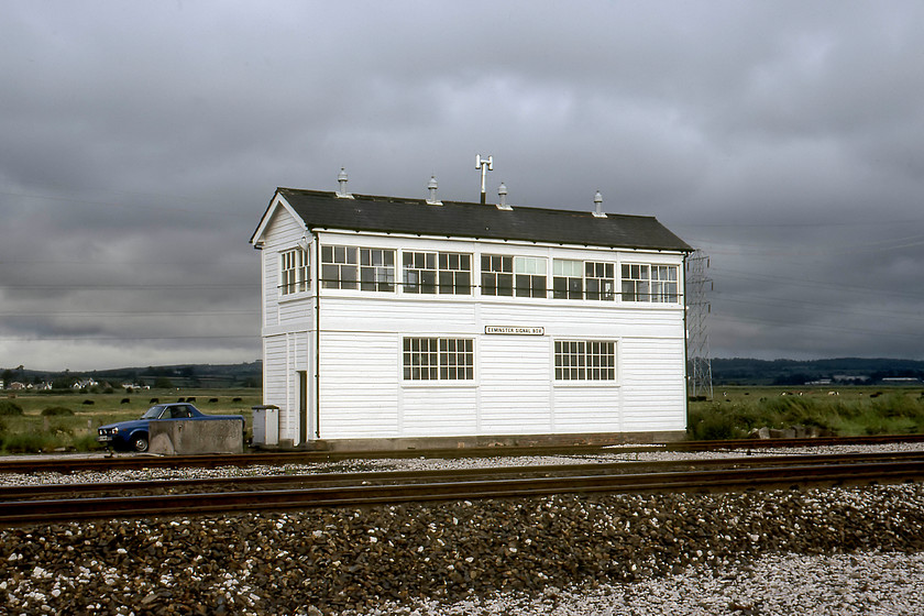 Exminster signal box (GW, 1924) 
 After a miserable two days of heavy cloud, rain and sea mist as we headed for home, and it brightened up! On passing Exminster we decided to turn right off the A379 in the village (some years before the Exminster bypass was opened) and headed down the lane leading towards the railway and the signal box. In this view, the 1924 GWR box looks very smart and as though it has been in receipt of a recent lick of paint. Notice the signalman's blue Saburu BRAT parked next to the box. The box survived until 1986 with it being converted to a bird-watching hide. By 2006 it had fallen out of use and was dismantled piece by piece and taken to the Gloucestershire and Warwickshire Railway for use on their Broadway extension. This did not take place as the box was deemed too big so they constructed a more appropriately sized box, see.... https://www.ontheupfast.com/p/21936chg/26925146604/broadway-signal-box As far as I know, the GWSR still have Exminster box safely stored - hopefully with every wooden panel carefully labelled! 
 Keywords: Exminster Signal Box