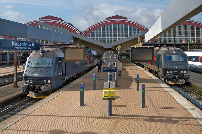 1537, 17.11 Copenhagen Central-Nykbing Falster & 1525, 16.56 sterport-Holbk, Copenhagen Central station 
 To the right, 1525 gets noisily away from Copenhagen Central with the 16.56 sterport to Holbk. To the left, the driver walks towards 1537 ready to get it away in five minutes time with the 17.11 to Nykbing Falster. I like the lighting in this photograph despite that it breaks the rules being rather side-lit! Notice the array of touching in machines arranged neatly in the foreground. 
 Keywords: 1537 17.11 Copenhagen Central-Nykbing Falster 1525 16.56 sterport-Holbk Copenhagen Central station DSB Class ME