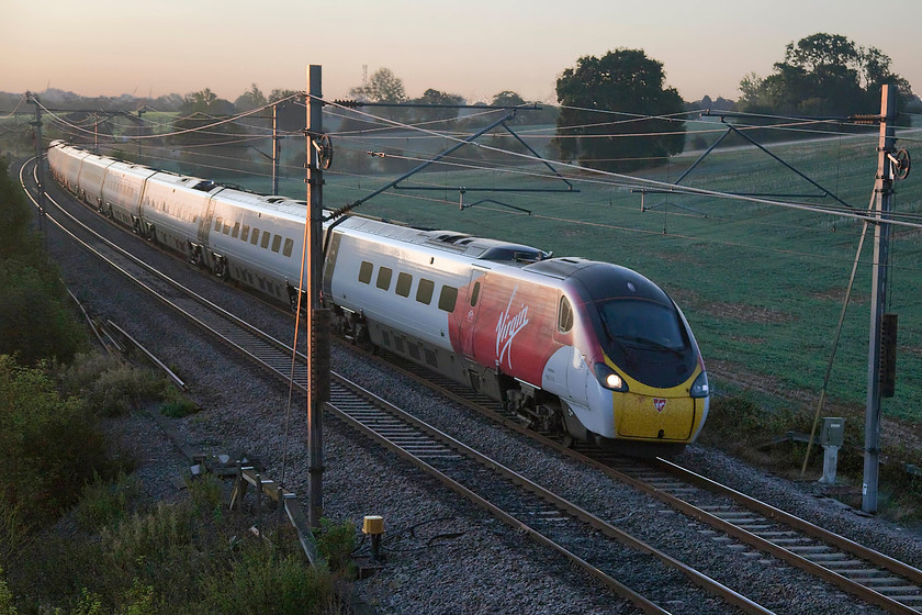 Class 390, VT 06.16 Manchester Piccadilly-London Euston (1H06, 3L), Blisworth 
 With the sun just peeking above the horizon, an unidentified class 390 passes Blisworth in Northamptonshire forming the 06.16 Euston to manchester Piccadilly, the first Virgin service to the north-west of the day. 
 Keywords: Class 390 06.16 Manchester Piccadilly-London Euston 1H06 Blisworth