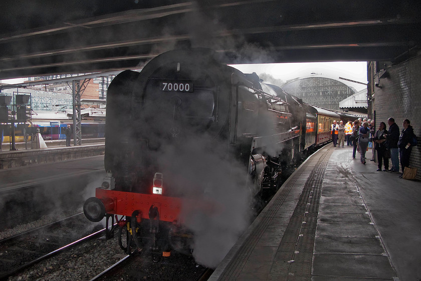 70000, outward leg of The West Somerset Steam Express, 08.06 London Paddington-Minehead West Somerset Railway (1Z70), London Paddington station 
 70000 'Britania' sits smack bang under Bishop's bridge at Paddington station thus making taking a reasonable photograph virtually impossible! It has been hauled in at the rear of The West Somerset Steam Express charter that it will soon lead heading for Minehead at 08.06 running as 1Z70. Behind where I am standing the platform end was absolutely packed with enthusiasts and people intending to travel on the train illustrating yet again how powerful the lure of steam remains. 
 Keywords: 70000 The West Somerset Steam Express, 08.06 London Paddington-Minehead West Somerset Railway 1Z70 London Paddington station WCR West Coast railways Britania