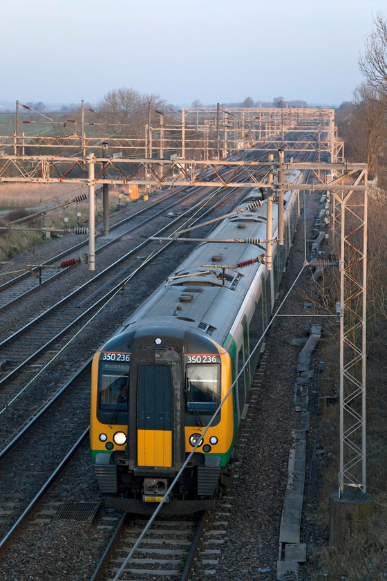 350236, LN 06.14 Birmingham New Street-London Euston (1Y04, 1E), Hungate End SP784465 
 The sun has just risen on what was a bitterly cold morning as London Northwestern 350236 passes Hungate End with the 06.14 From Birmingham to London Euston. This location is about a mile south of Hanslope Junction and crossovers between Northampton and Milton Keynes.