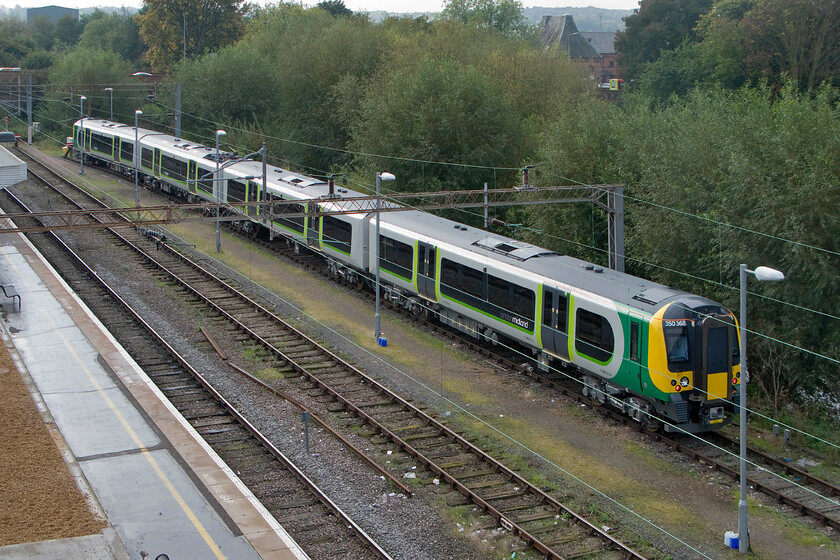 350368, stabled (new), Northampton Riverside sidings 
 Taken from the lofty heights of Northampton station's temporary footbridge brand new and out of the box 350368 is seen stabled in the Riverside sidings. London Midland have ordered ten of these units to augment their services beyween London, Birmingham, Liverpool and the Cross City route. The arrival of these new units will allow London Midland to withdraw the Class 323s on the latter of these routes. 
 Keywords: 350368 Northampton Riverside sidings