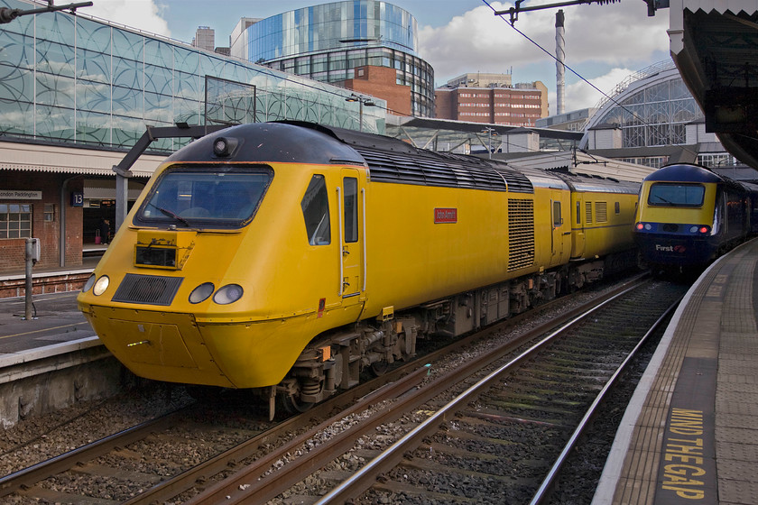 43062, 13.29 London Paddington-Derby RTC NMT (1Q21), London Paddington station 
 The NMT aka 'Flying Banana' has just arrived at Paddington station after running up from Exeter Riverside. the crew are quickly changing ends and making ready for a departure so as yo avoid blocking a platform for too long. 43062 'John Armitt' will lead the 1Q21 13.29 departure for Derby RTC where the NMT is based. Adjacent to the yellow train is a far more sombre and unidentified First Great Western power car that has arrived with a service from the West Country. Being on this side of Paddington station it is probably ex Hereford or Cheltenham. 
 Keywords: 43062 13.29 London Paddington-Derby RTC NMT 1Q21 London Paddington Station Flying Banana New Measurement Train John Armitt