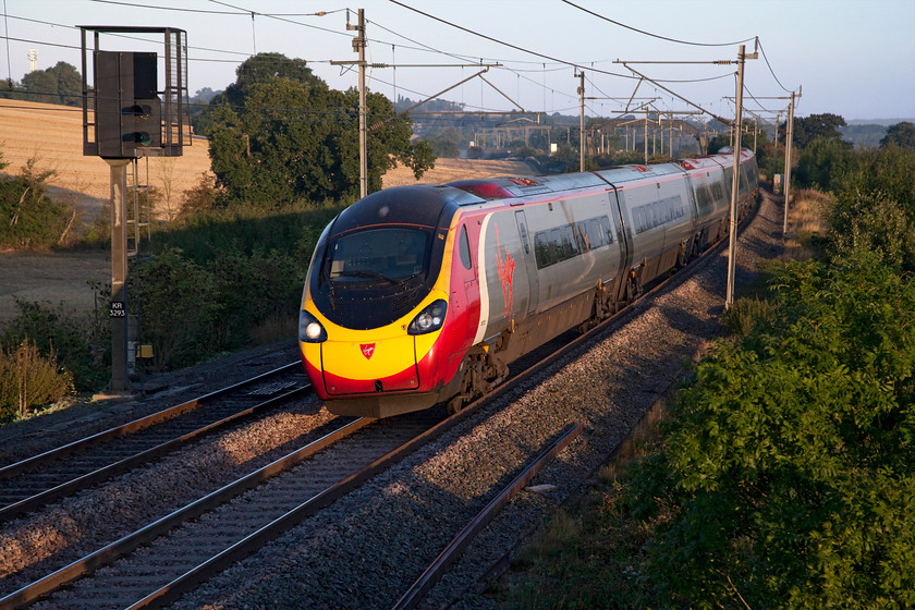 390121, VT 05.45 Wolverhampton-London Euston (1R04, 3L), Milton Crossing 
 I lovely early morning light 390121 'Virgin Dream' passes Milton Crossing on the Weedon Loop just before it re-joins the Northampton line in Roade Cutting. The Pendolino is is working the 05.45 Wolverhampton to Euston 1R04 train. 
 Keywords: 390121 1R04 Milton Crossing