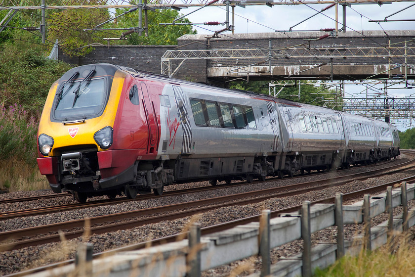 221107, VT 11.50 Birmingham New Street-London Euston (1B40, 5L), Old Linslade 
 221107 'Sir Martin Frobisher' passes under a farm occupation bridge at Old Linslade. The Voyager is working the 11.50 Birmingham New Street to London Euston. Notice the concrete and white asbestos cable carrying conduits in the foreground. In the past, these were a common sight throughout the network but now have all but disappeared as lineside cable is largely buried in the ballast. 
 Keywords: 221107 1B40 Old Linslade