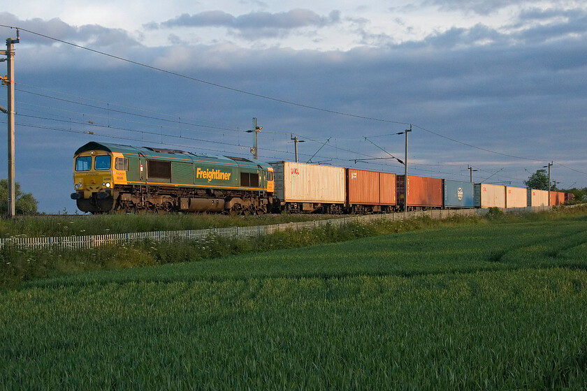 66566, 02.08 Trafford Park-Felixstowe North (4L92, 22E), Milton Malsor SP740557 
 Sollouted against a dramatic sky illuminated by the early morning rising sun creates an interesting backdrop at Milton Malsor just south of Northampton. 66566 emerges from a short cutting leading the 02.08 Trafford Park to Felixstowe Freightliner. The 4L92 is not a fright that I have many images of due to its very early morning timings here in Northamptonshire. 
 Keywords: 66566 02.08 Trafford Park-Felixstowe North 4L92 Milton Malsor SP740557 Freightliner