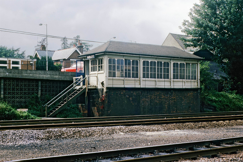 Radlett signal box (Midland, 1890) 
 Radlett signal box was situated just north of the station adjacent to the fast lines. Here, the box is seen in a little bit of weak sunshine approximately four months before its closure as the MML MAS scheme was switched on. The box was a Midland structure dating from 1890. Notice the two fire buckets on hooks below the wooden steps and the signaman's two-door red Ford Cortina parked behind the box. 
 Keywords: Radlett signal box