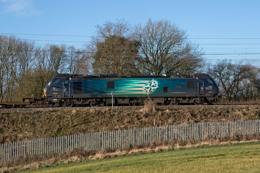 88003, 05.33 Tilbury-Coatbridge (4S10, 7E), between Roade & Ashton 
 A side-on view of 88003 'Genesis' as it passes between Roade and Ashton in Northamptonshire leading the 05.33 Tilbury to Coatbridge DRS operated intermodal. This 4S10 flow is a relatively new one and brings the opportunity to capture a Class 88 passing through Northamptonshire that is not a particularly common event. With the loss of the Class 86s last year Class 88s bring a little more variety to this part of the world making a change from chugging 66s and has been 90s! 
 Keywords: 88003 05.33 Tilbury-Coatbridge 4S10 between Roade & Ashton Genesis Direct Rail Services DRS