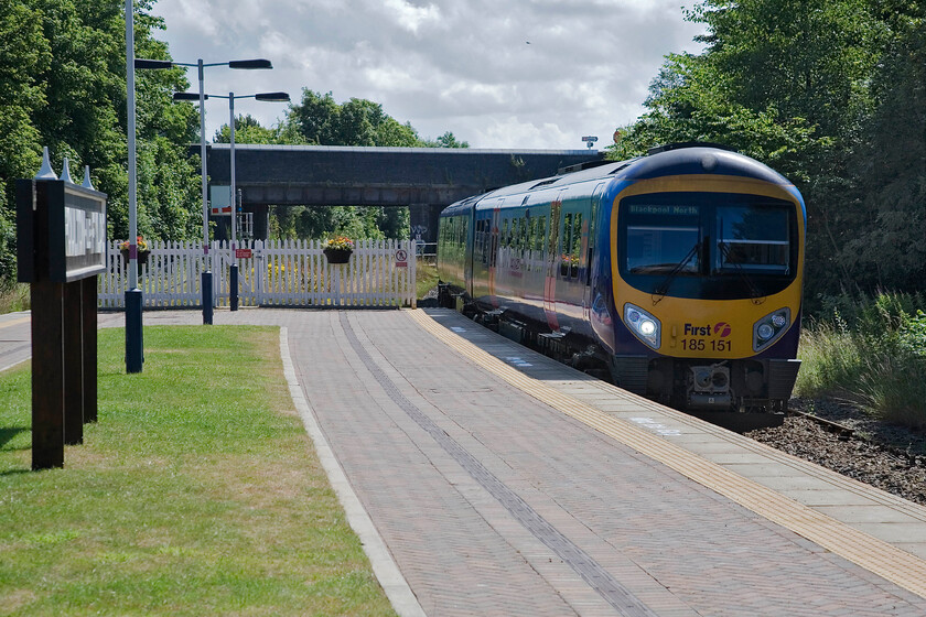 185151, TP 10.29 Manchester Airport-Blackpool North, Poulton-le-Fylde station 
 Horribly back lit the 10.29 Manchester Airport to Blackpool North arrives at Poulton-le-Fylde station worked by TPE's 185151. Note the neatly manicured grass and planters hanging from the fence on the platform end thanks to the friends of the station and sponsored by a local nursery, 
 Keywords: 185151 10.29 Manchester Airport-Blackpool North Poulton-le-Fylde station TPE Trans Pennine Express