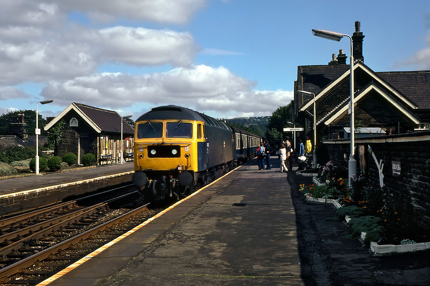 47456, 07.05 Glasgow Central-Nottingham (1M70), Settle station 
 47456 arrives at Settle station leading the 07.05 Glasgow Central to Nottingham service. Given the Settle and Carlisle's poor service pattern at this time with sustained discussions over its closure, I suspect that this was the first southbound passenger train of the day. Notice that there is a number of passenger waiting on the platform to catch the train and the neat and well-kept flower beds. 
 Keywords: 47456 07.05 Glasgow Central-Nottingham 1M70 Settle station