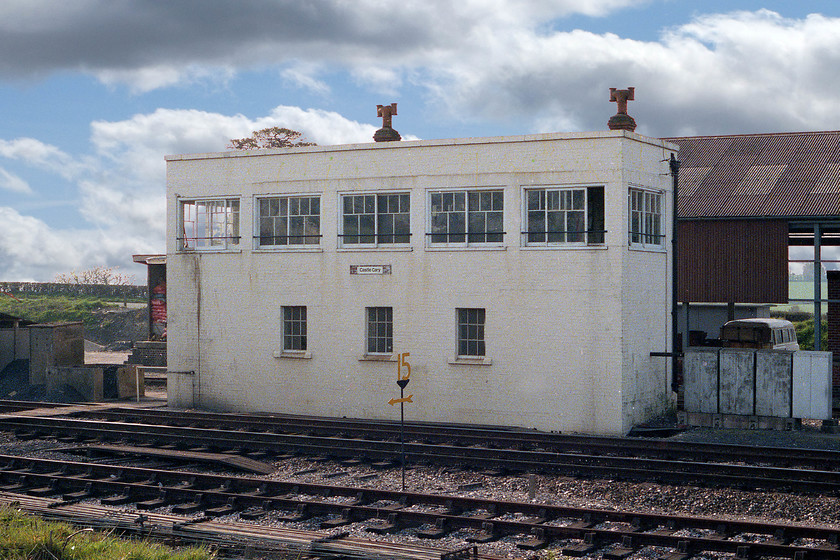 Castle Cary signal box(GWR, 1943) 
 Castle Cary signal box was not quite a classic GWR design! It was rebuilt following a German air raid in September 1942 that destroyed the original structure. I am not sure that painting it white has improved its utilitarian looks? Note the brown stains at the left-hand end where the signalmen emptied their teapot from the window! The fifteen miles per hour speed restriction sign in the foreground refers to pointwork where the Weymouth line diverges just off to the left. 
 Keywords: Castle Cary signal box