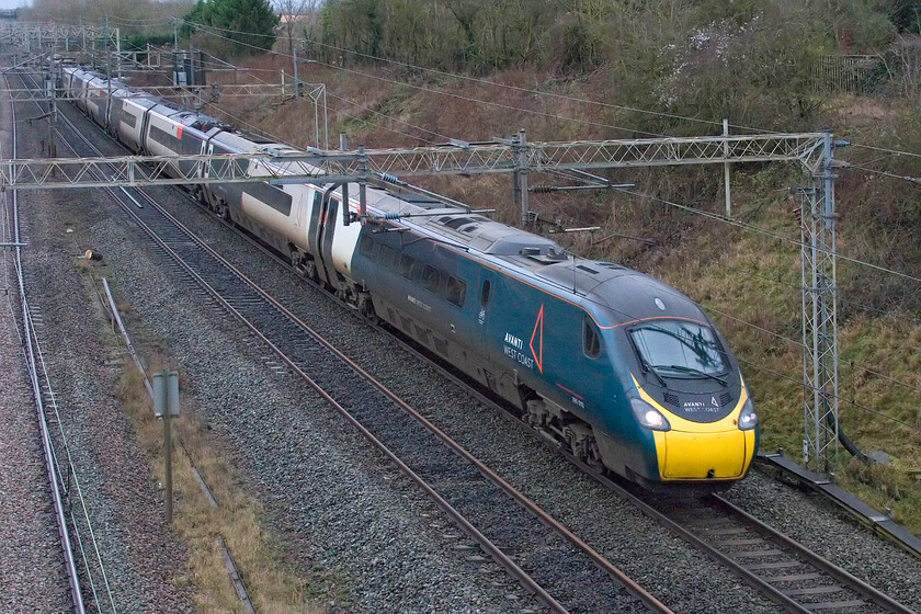 390010, VT 13.15 London Euston-Preston (9S77, RT), Victoria bridge 
 390010 'Cumbrian Spirit' passes Victoria bridge between Roade and Ashton working Avanti's 13.15 Euston to Preston service. This Pendolino was named back in 2016 by Virgin following the devastating floods that afflicted many in Cumbria and their response to it. Unfortunately, like all named Pendolinos, the attractive cast plates were replaced by vinyl stickers this one being the first to undergo this when it was re-liveried into Virgin's flowing silk livery back in October 2017. 
 Keywords: 390010 13.15 London Euston-Preston 9S77 Victoria bridge Cumbrian Spirit AWC Avanti West Coast Pendolino