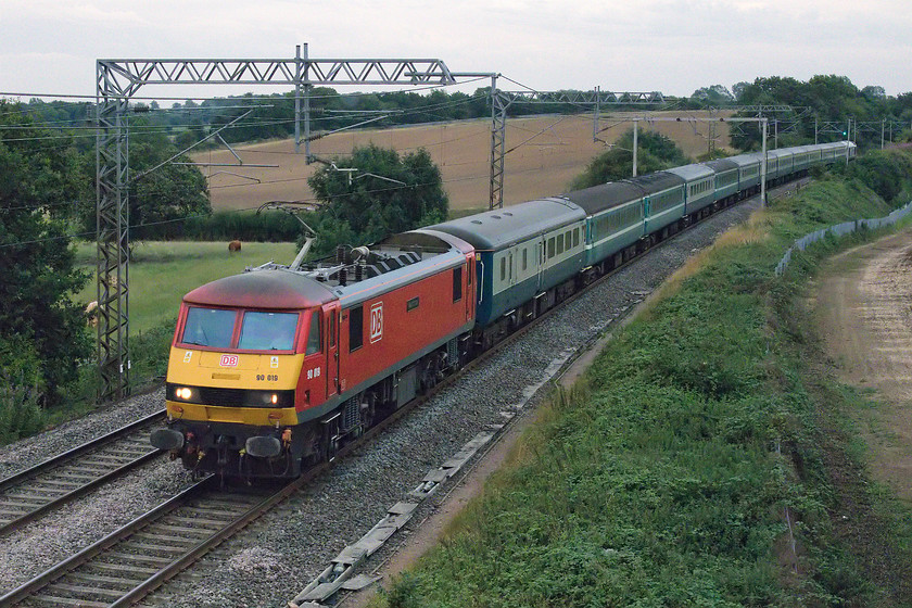 90019, 19.16 Wembley Central-Liverpool South Parkway footex (1Z91), Milton Crossing 
 90019 'Intermodal' leads the return 19.16 Wembley Central to Liverpool South Parkway footex past Milton Malsor. The train was full of disappointed Liverpool supporters who had witnessed their team beaten 5-4 on penalties by Manchester City at Wembley. In doing this, they had lost the season-opening Community Sheild, where the winners of the previous season's league play the winners of the FA Cup. As Manchester City won both, then the runners up in the league play the FA Cup champions. 
 Keywords: 90019 19.16 Wembley Central-Liverpool South Parkway footex 1Z91 Milton Crossing