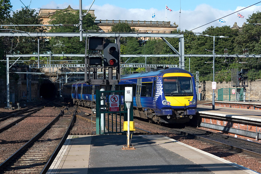 170427, SR 09.45 Edinburgh Waverley-Glasgow Queen Street (1R07), Edinburgh Waverley station 
 170427 leaving Edinburgh Waverley with the 09.45 to Glasgow Queen Street. It is just entering the 15 chain-long Mound Tunnel. On top, with the Union and saltir flags fluttering in the southerly breeze, is the Scottish National Gallery. I have visited it a number of times and in the quieter galleries the trains can be felt and heard in the tunnel directly below! 
 Keywords: 170427 09.45 Edinburgh Waverley-Glasgow Queen Street 1R07 Edinburgh Waverley station