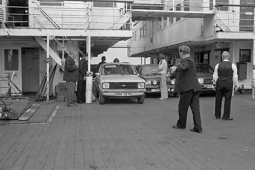 Unloading MV Farringford, Hull Corporation Pier 
 Crew members aboard MV Farringford continue about their work to disembark the cars from the deck of the vessel after it has arrived at Hull Corporation Pier with the 16.50 sailing from New Holland Pier. The locally registered (Hull) beige two-door 1100 Escort estate is next off probably followed by the natty Fiesta Mk. I complete with driving and fog lamps fitted probably next; is that its driver standing in front of the car waiting for the room to get to the driver's door? It's sobering to consider that four crew members seen at work on the deck of MV Farringford here would lose their jobs in exactly a week's time when the ferry service would close with the opening of the Humber bridge some five miles upstream at Hessle 
 Keywords: Unloading MV Farringford Hull Corporation Pier Ford Escort