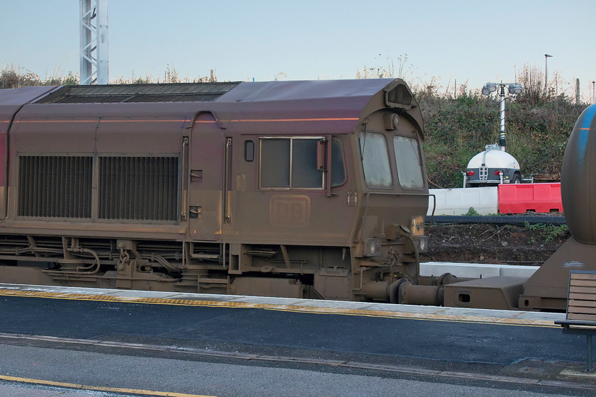 66197, 11.53 West Hampstead North-Toton, Wellingborough station 
 Having been halted at Wellingborough station, the rear of 66197 stands as the lead locomotive of the 11.53 West Hampstead to Toton railhead treatment train. The locomotives involved in this seasonal work get absolutely filthy and 66197 is no exception. They catch the spray from the high-pressure jets that are aimed at the railhead as it moves along at a fairly leisurely pace. However, the spray is contaminated by the muck that it is intended to clear hence the filth that pervades the locomotives and stock. 
 Keywords: 66197 11.53 West Hampstead North-Toton Wellingborough station