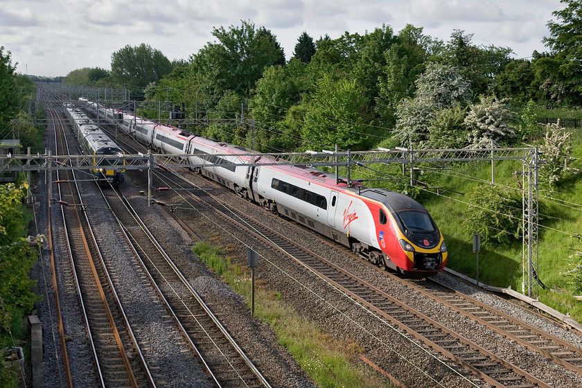 350236, LM 07.05 London Euston-Birmingham New Street (2Y07) & 390103, VT 07.43 London Euston-Carlisle (9S47), Victoria bridge 
 The race is on! Yet another Pendolino running with its nose cone cover in the open position is seen passing Victoria bridge near to Roade. Named 'Virgin Hero' it was decided that 390103 should carry Royal British Legion World War I commemorative branding and this was applied last year. It is seen working the 07.43 Euston to Carlisle train passing 350236 on the 07.05 Euston to Birmingham New Street. 
 Keywords: 350236 07.05 London Euston-Birmingham New Street 2Y07 390103 07.43 London Euston-Carlisle 9S47 Victoria bridge Virgin West Coast Pendolino London Midland Desiro Royal British Legion World War I commemorative branding