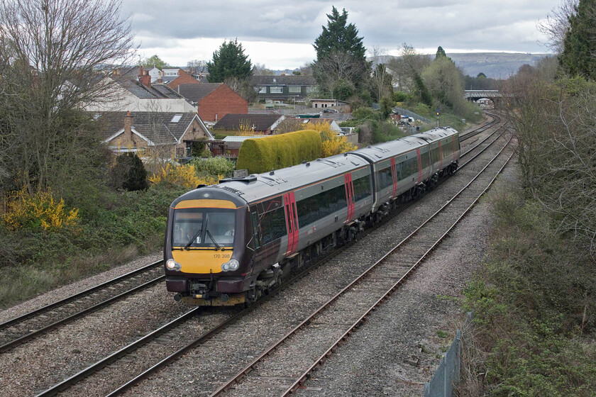 170398, XC 15.07 Nottingham-Cardiff Central (1V12, RT), Cloddy bridge 
 With the Cotswold escarpment in the background, 170398 leaves Cheltenham past Cloddy bridge working the 1V12 15.07 Nottingham to Cardiff Central service. As can be seen from the skyscape, the weather was not particularly kind on this early April afternoon with a keen and chilly wind also blowing making me once again think that maybe I should be somewhere more pleasant than standing on an exposed bridge watching trains pass! 
 Keywords: 170398 15.07 Nottingham-Cardiff Central 1V12 Cloddy bridge CrossCountry