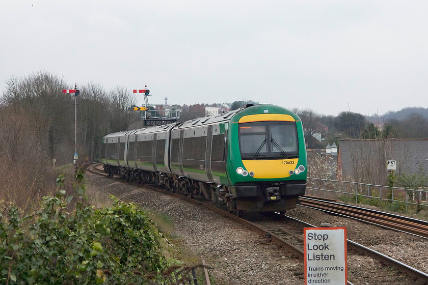 170633, LM 13.49 Birmingham New Street-Hereford (1V28, 1E), Worcester Foregate Street station 
 London Midland's 170633 runs down the grade into Worcester Foregate Street station as the 1V28 13.49 Birmingham to Hereford. It has just passed two sets of signals controlled by different boxes. The one to the left is TU20 and acts as the up starter from Foregate Street controlled by Tunnel Junction and is for Birmingham trains. The bracket to the right is HK5 controlled by Henwick box and is the up starter for trains towards Shrub Hill the fixed distant for which is below the home. Given the distance that TU20 and HK5 are from their respective boxes, they are both motorised. 
 Keywords: 170633 1V28 Worcester Foregate Street station