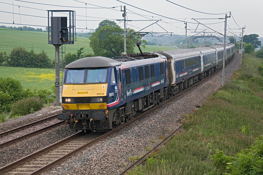 90016, SR 19.50 Fort William, 20.44 Inverness & 21.42 Aberdeen-London Euston (1M16), Milton Crossing 
 The up 'Highland Sleeper' passes Milton crossing just north of Roade led by 90016. The 19.50 Fort William/20.44 Inverness/ 21.42 Aberdeen to Euston service was bang on time today with the passengers on board no doubt being awoken from their slumber in preparation for arrival into London in about forty minutes. 
 Keywords: 90016 19.50 Fort William, 20.44 Inverness 21.42 Aberdeen-London Euston 1M16 Milton Crossing Caledonian sleeper