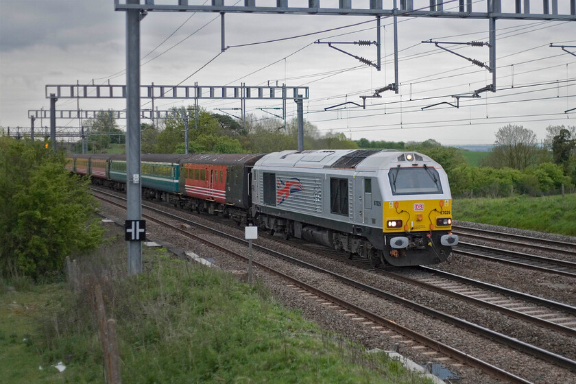 67026, 18.42 London Euston-Northampton footex (1Z11), Ashton Road bridge 
 Still looking very smart in its one-of-special livery applied last year and unveiled by HRH The Queen, 67026 'Diamond Jubilee' leads the 18.42 Euston to Northampton footex. Seen approaching Roade, the train was carrying disappointed Cobbers supporters back from their day out at Wembley where their team was beaten 3-0 by Bradford City in the League Two playoff final. Notice the rag-bag collection of stock the passengers were travelling in not that they will probably have noticed that! 
 Keywords: 67026 18.42 London Euston-Northampton footex 1Z11 Ashton Road bridge Diamond Jubilee